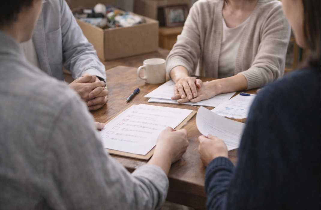 遺品整理について家族で書類を確認し話し合っている様子